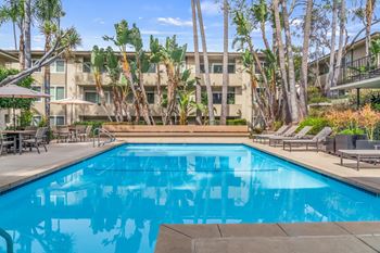 A swimming pool surrounded by palm trees and lounge chairs at West Park Village, Los Angeles, 90025